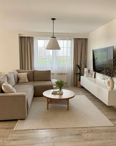 a living room filled with furniture and a flat screen tv on top of a wooden table