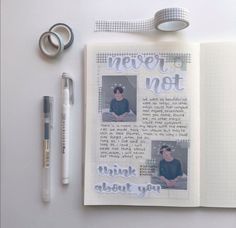 an open notebook with two photos and some pens