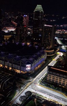 an aerial view of a city at night with lots of lights and buildings in the background