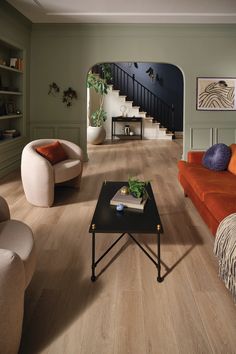 a living room filled with furniture and a fire place next to a stair case on the wall