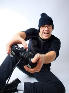 a man sitting on the floor with a video game controller in his hand and laughing