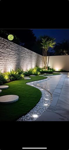 an outdoor garden at night with lights on the walls and grass in the foreground