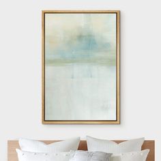 a bed with white pillows and a painting above it