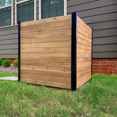 a wooden box sitting in the grass next to a house