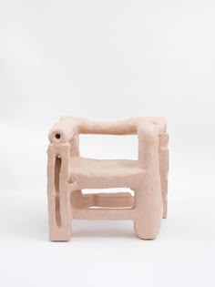 a small chair made out of clay on a white background