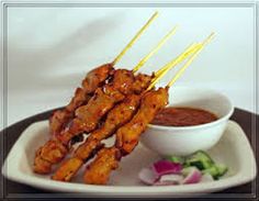 chicken skewers with dipping sauce on a white plate