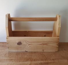 a wooden crate sitting on top of a wooden floor next to a wall with a white wall in the background