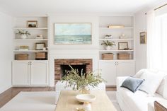 a living room with white furniture and a fireplace