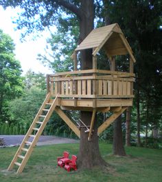 a tree house with a fire hydrant in the foreground and a ladder leading up to it