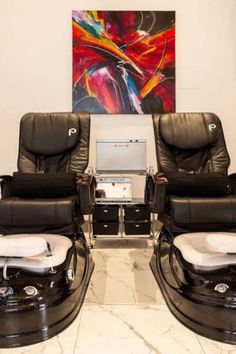 two reclining chairs in front of a painting