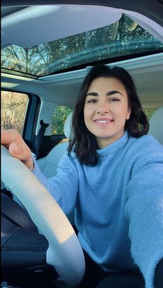 a woman sitting in the driver's seat of a car