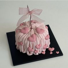 a cake with pink icing and hearts on it