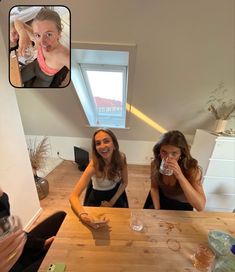 two women sitting at a table drinking wine