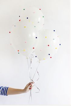 a person holding three white balloons in their hand with the caption simplving