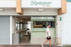 a man walking past a store front with the door open