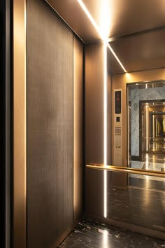 an elevator with a mirror and lights on the wall next to it's doors