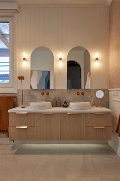 a bathroom with two sinks and three mirrors