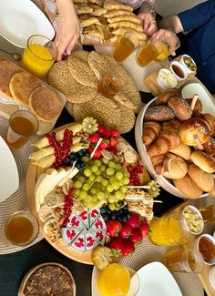 a table full of breads, fruit, and other food on plates with drinks