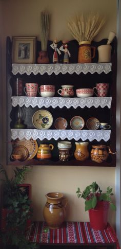 a shelf filled with lots of dishes on top of a table