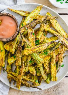 grilled asparagus on a plate with dipping sauce