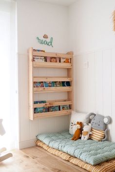 a child's room with bookshelf and stuffed animals on the bed in it