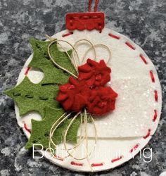 a felt christmas ornament with red and green decorations