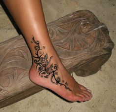 a woman's foot with a tattoo design on it, and the bottom part of her leg