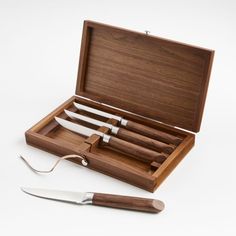 a wooden box with four knives in it