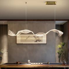 a dining room with a wooden table and white lights hanging from it's ceiling