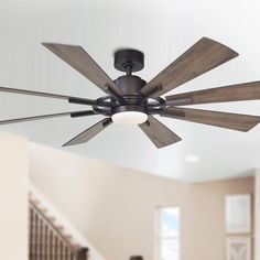 a ceiling fan with five wooden blades in a living room