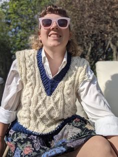 a woman wearing sunglasses sitting on top of a chair