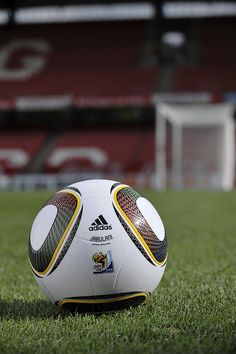 a soccer ball sitting on top of a lush green field