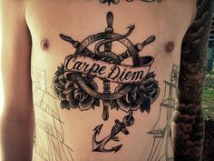 a man with a tattoo on his back has an anchor, roses and the words carpe diem