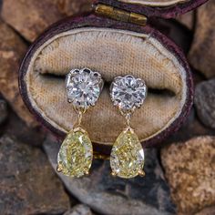 This lovely pair of dangle earring are each accented with one (1) pear modified brilliant cut fancy yellow colored diamond set into a three-prong setting and one (1) round brilliant cut diamond set into a platinum four- prong setting. The earrings are finished with platinum friction backs and posts for pierced ears. Yellow Diamond Earrings With Diamond Accents, Luxury Pear-shaped Single Cut Diamond Earrings, White Gold Pear-shaped Earrings With Single Cut Diamonds, Pear-shaped Single Cut Diamond Earrings, Yellow Diamond Earrings In Fine Jewelry Style, Fine Jewelry Yellow Diamond Earrings, Pear-shaped Diamond Earrings In White Gold, Yellow Diamond Earrings With Diamond Accents For Wedding, Yellow Diamond Earrings With Accents For Wedding