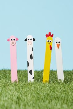 four wooden pegs in the shape of three farm animals, one with a chicken and one with a cow