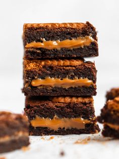 four brownies stacked on top of each other with caramel drizzles