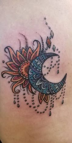 a woman's stomach with a sunflower and moon tattoo on the side of her back