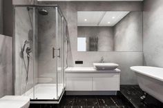 a bathroom with a sink, toilet and bathtub next to a shower stall in the middle of the room