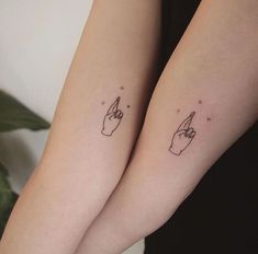 two small tattoos on both arms with fingers pointing to the sky and stars above them