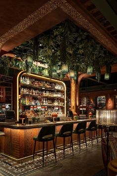 the bar is decorated with greenery and hanging from the ceiling, along with black chairs