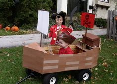 two children dressed up as pirates in a wooden boat