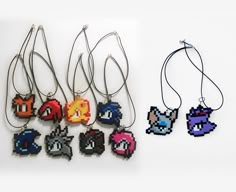 several necklaces with different types of video games characters on them, all in pixel style