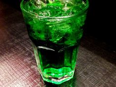 a green drink sitting on top of a wooden table