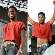 two men with their arms in the air and one wearing an orange shirt on stage