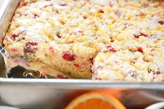 a close up of a cake in a pan with oranges and other food around it