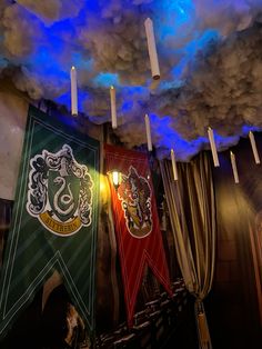 hogwarts banners hanging from the ceiling in front of blue and white clouds above them