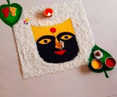 an artisticly decorated mat with candles and decorations on the floor in front of it