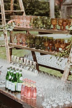 an outdoor bar with many glasses and bottles on it