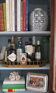 a book shelf filled with lots of books and liquor bottles on top of each other