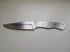 a knife that is sitting on top of a white surface with the blade cut out